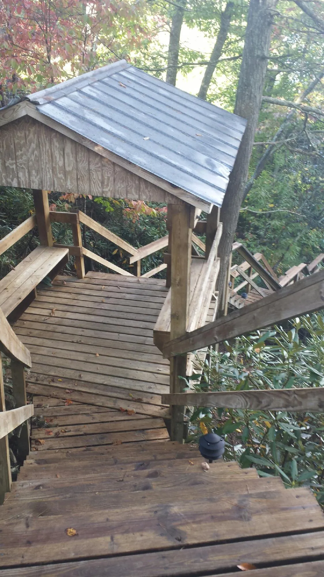 Metal roofed shelter over wooden steps on a wooded walkway — Skylight Repair & Installation work by our crew in Wessington Springs